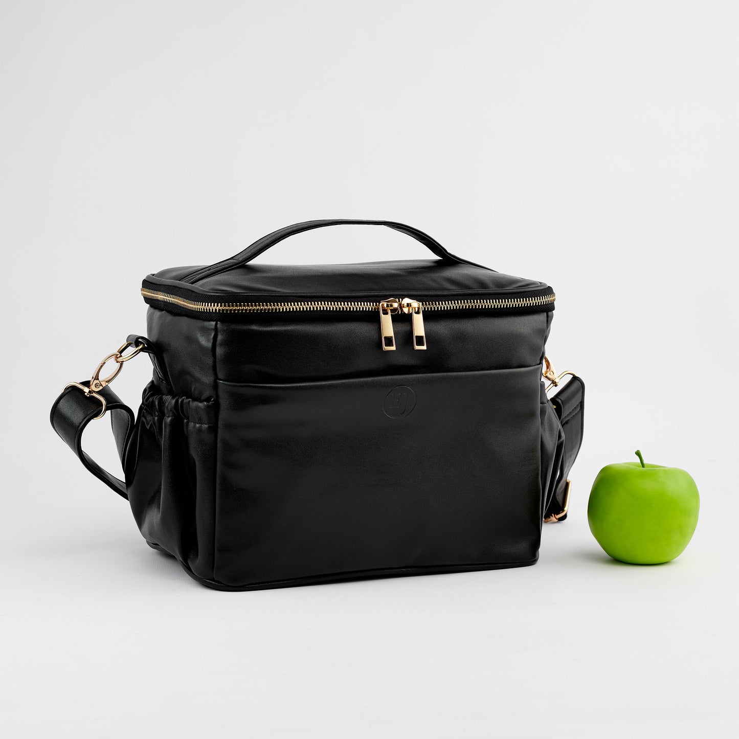 black faux leather lunch bag with a fresh apple snack