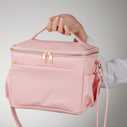 a model hand holding an elegant and cute pink leather lunch bag