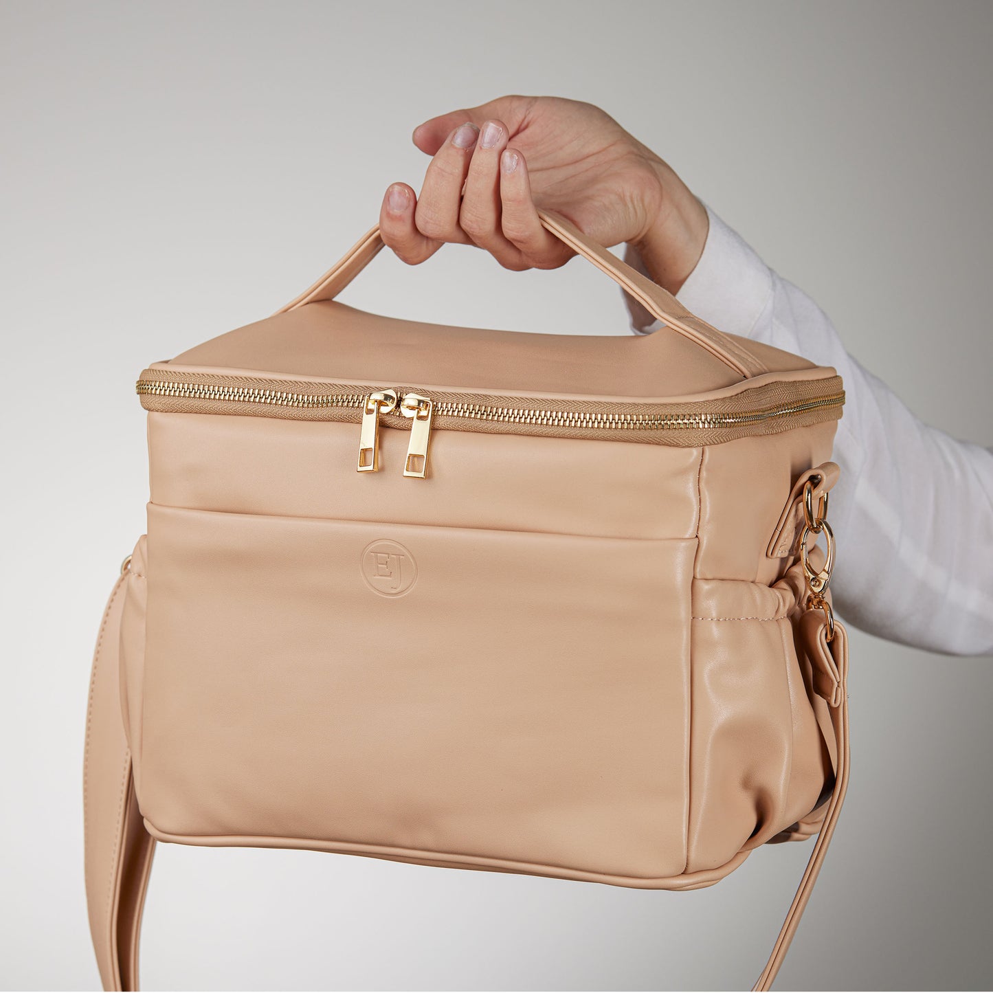 leather lunch bag in caramel beige being held up by a model